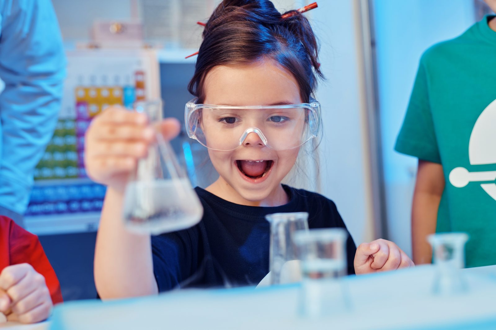 Dziewczynka w okularach ochronnych przeprowadza eksperyment naukowy na zajęciach Superminds Academy